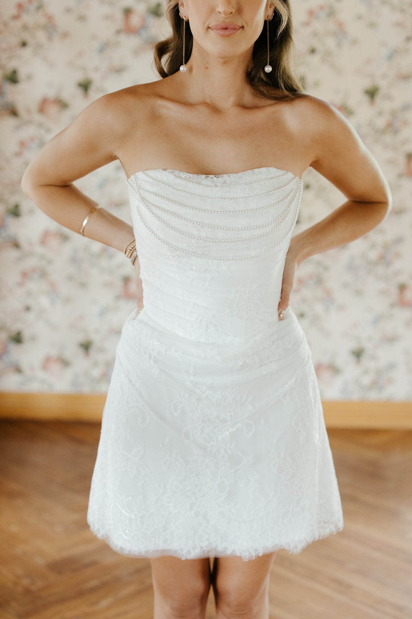 Woman wearing a strapless white dress with a floral background