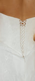 White wedding dress with intricate back design on a blurred background