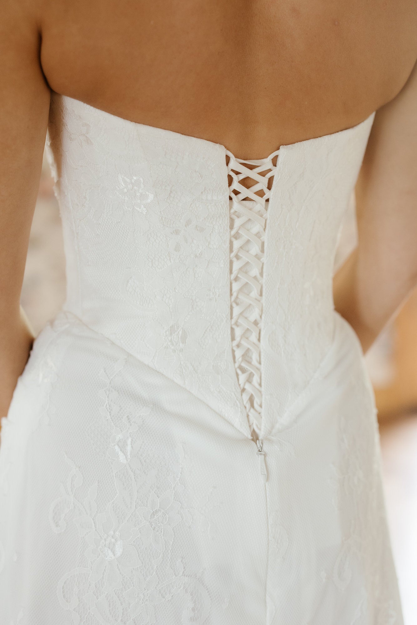 White wedding dress with intricate back design on a blurred background