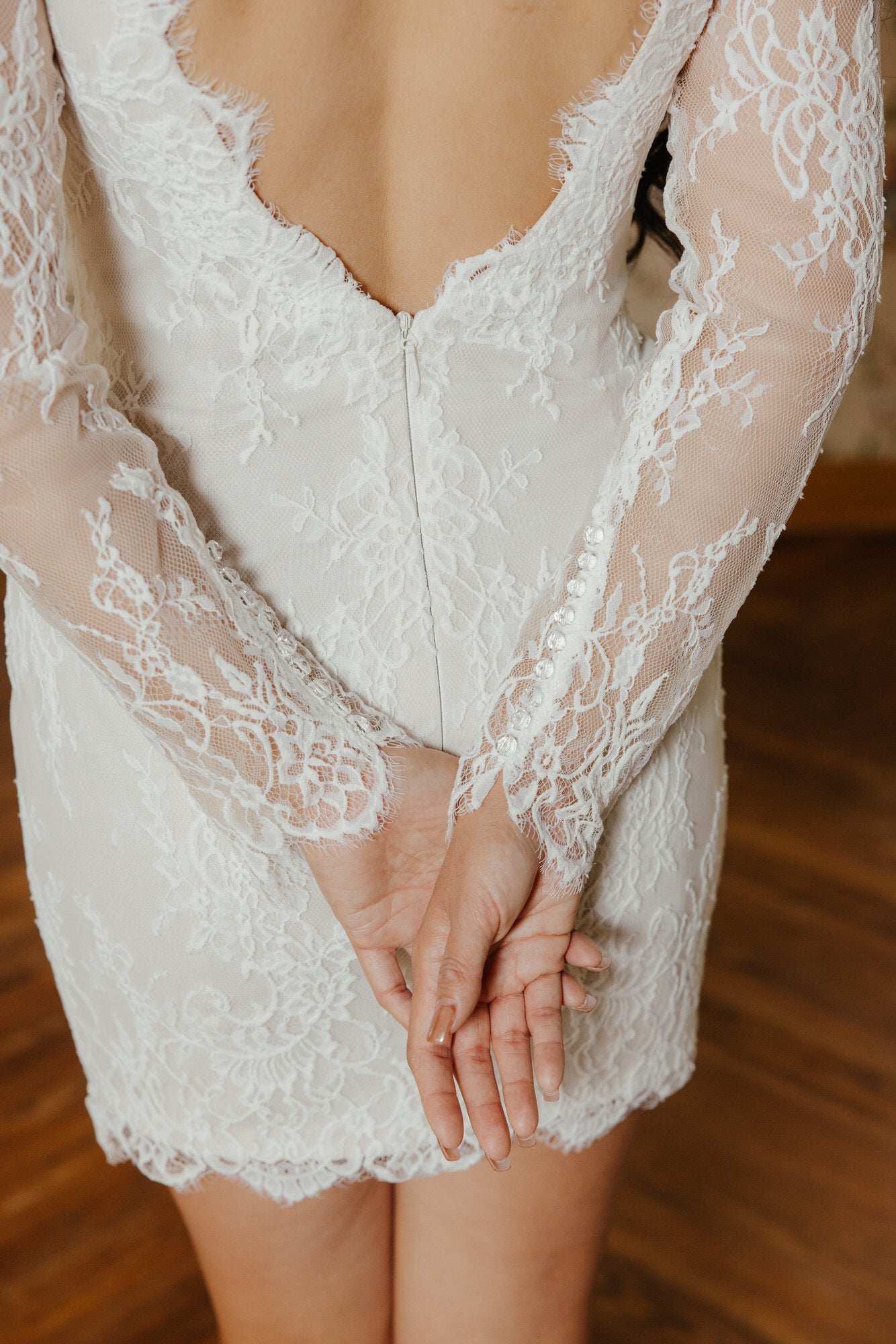 White lace dress with long sleeves on a wooden floor