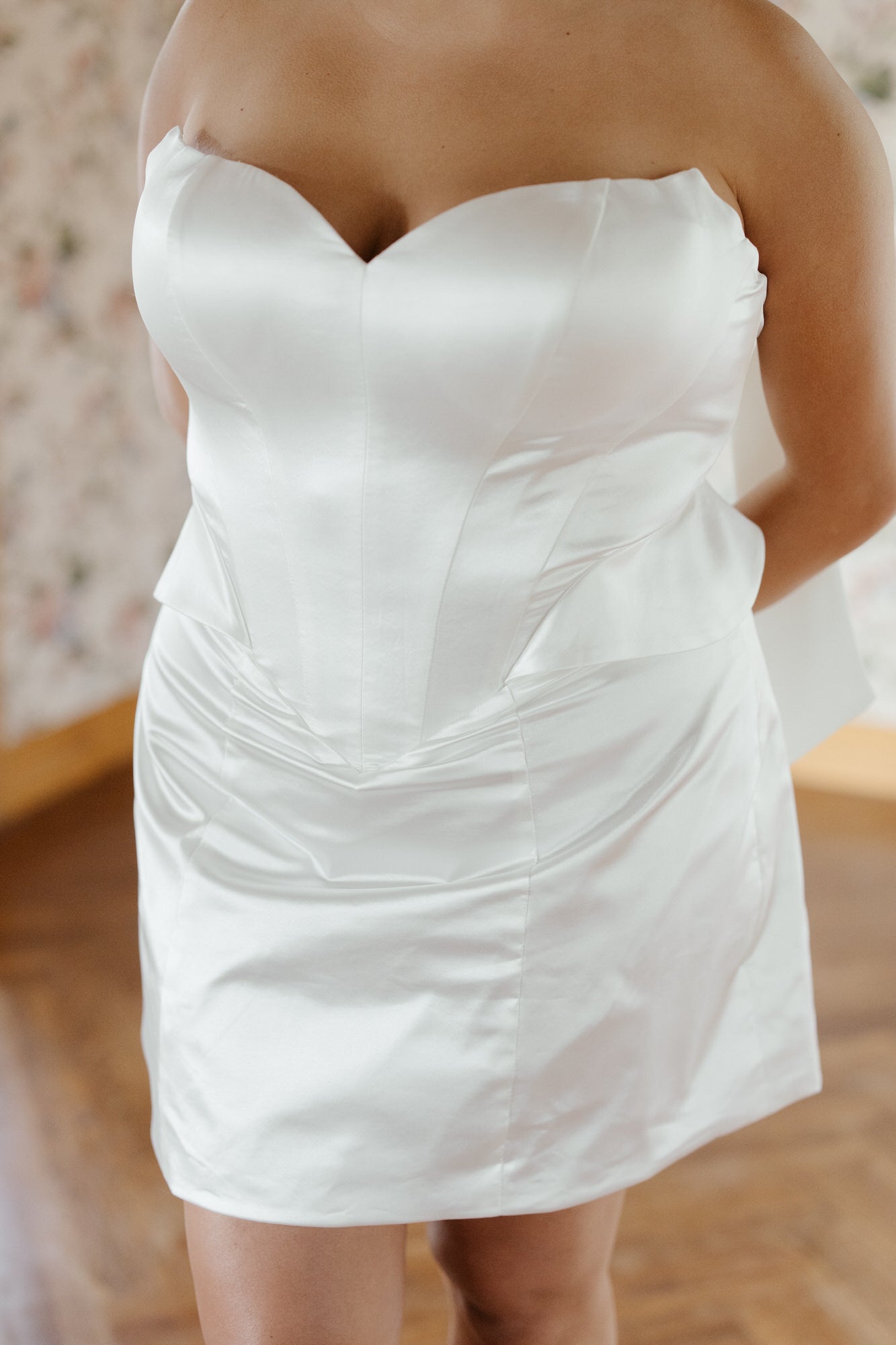 White strapless dress worn by a person with a blurred background