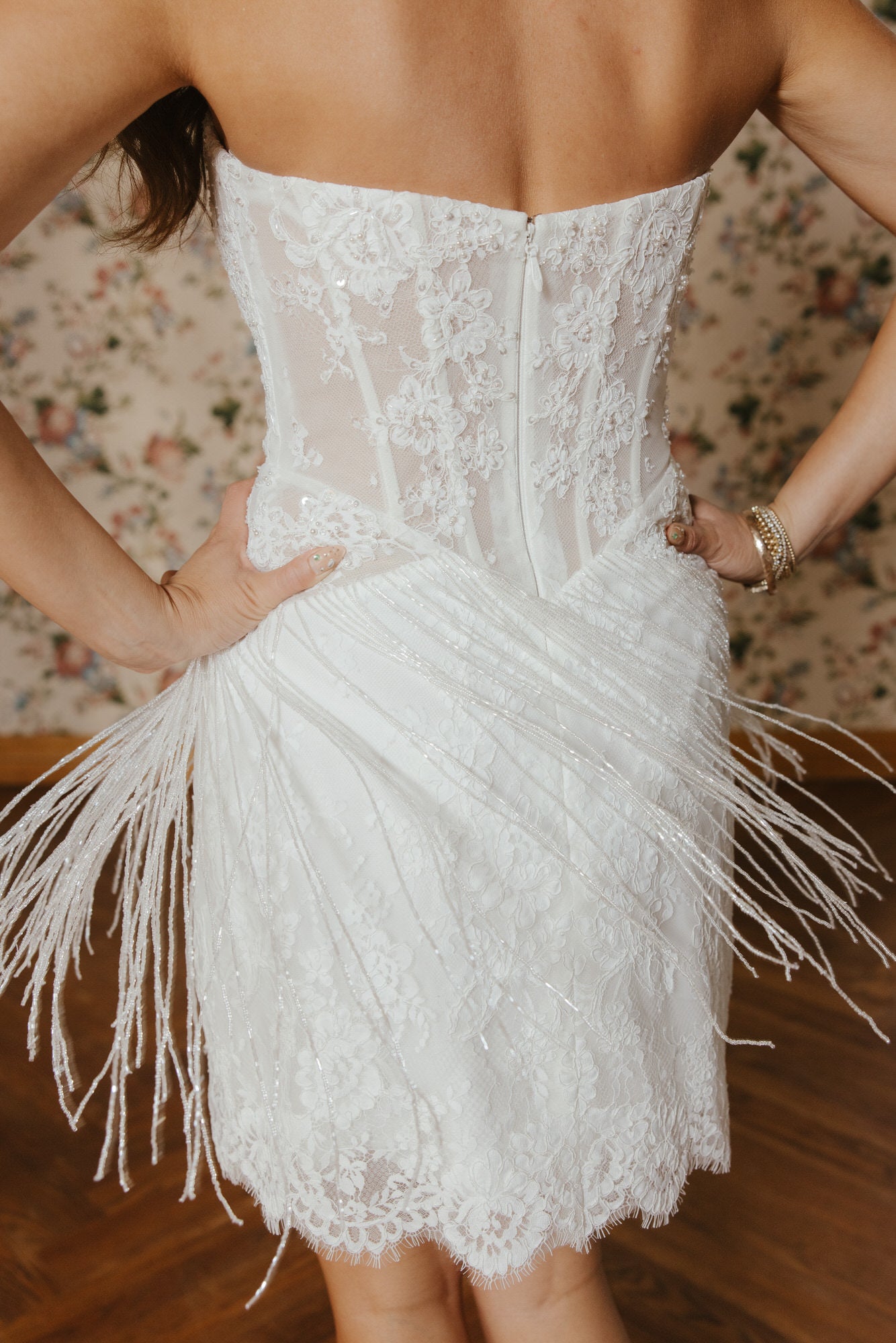 White lace dress with fringe details on a floral background