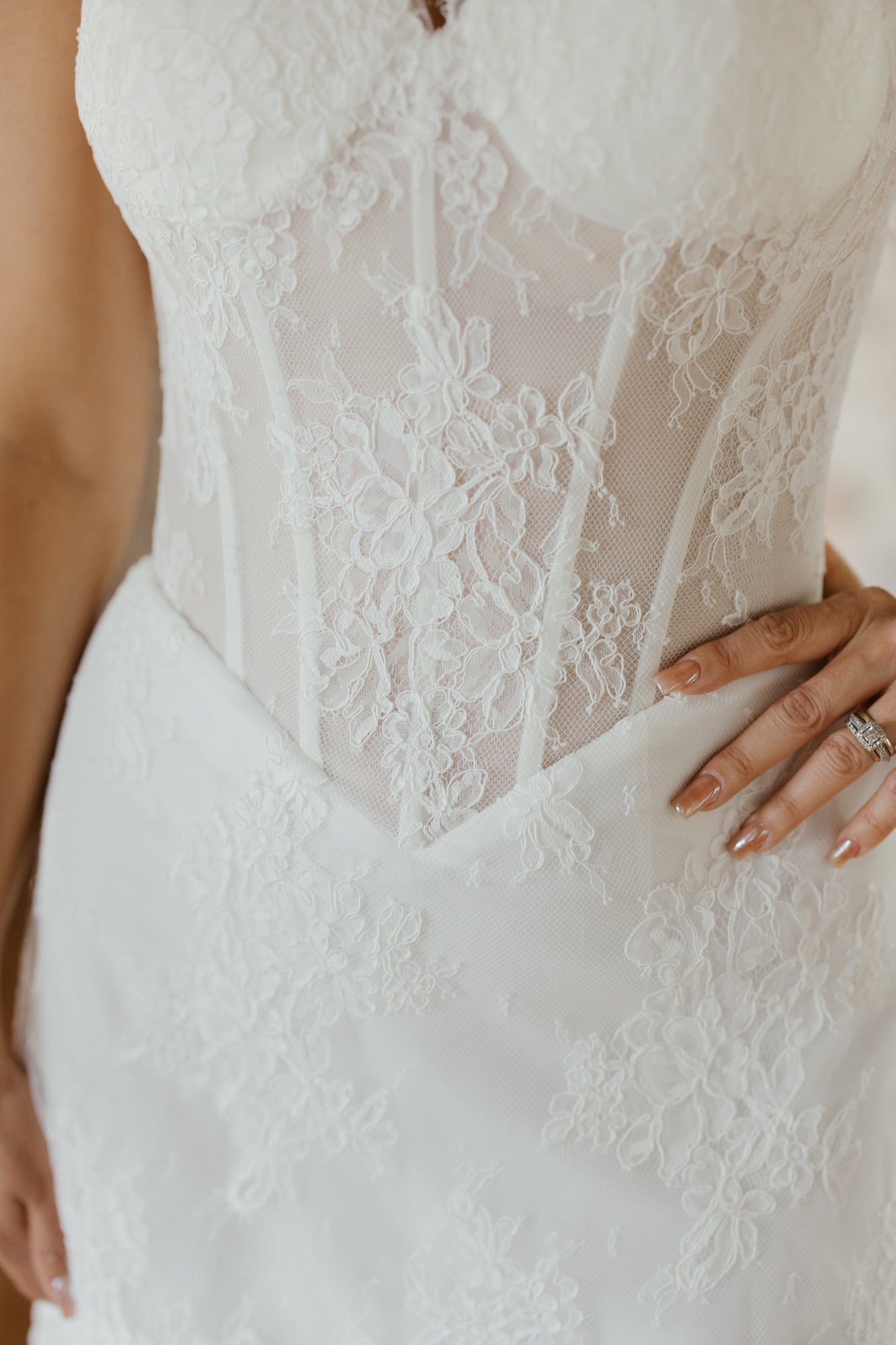 Close-up of a white lace wedding dress with a blurred background